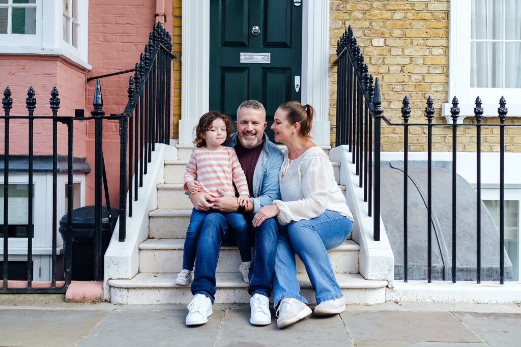 Family sitting together on front step of their house